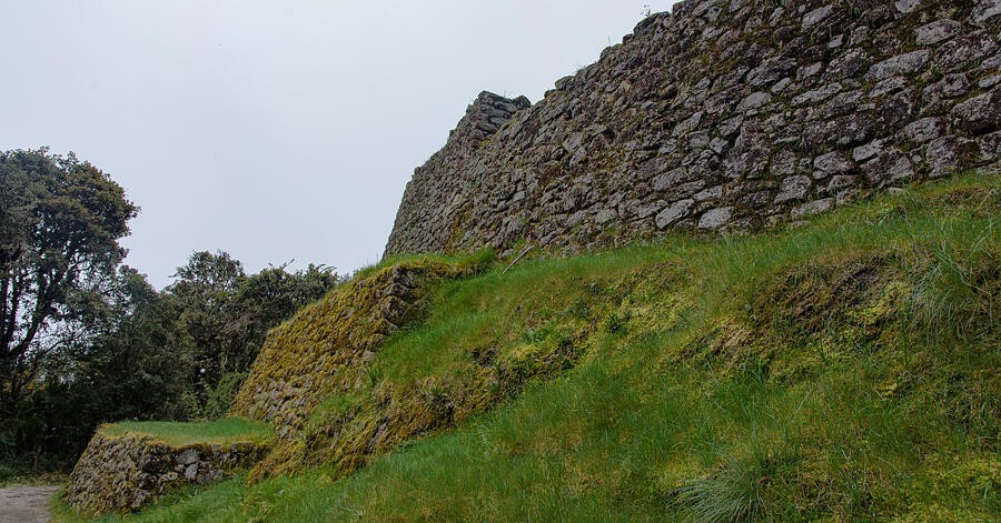 A Green Slope Beneath the Weathered Stone Wall