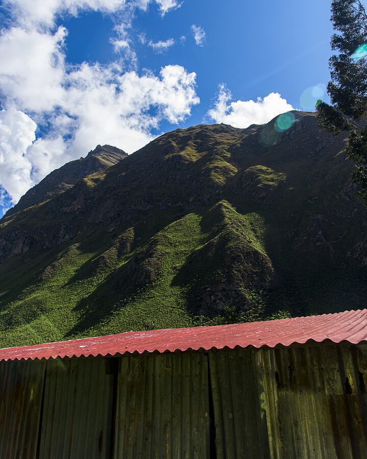A Red Roof Below the Shadowed Mountain Crest