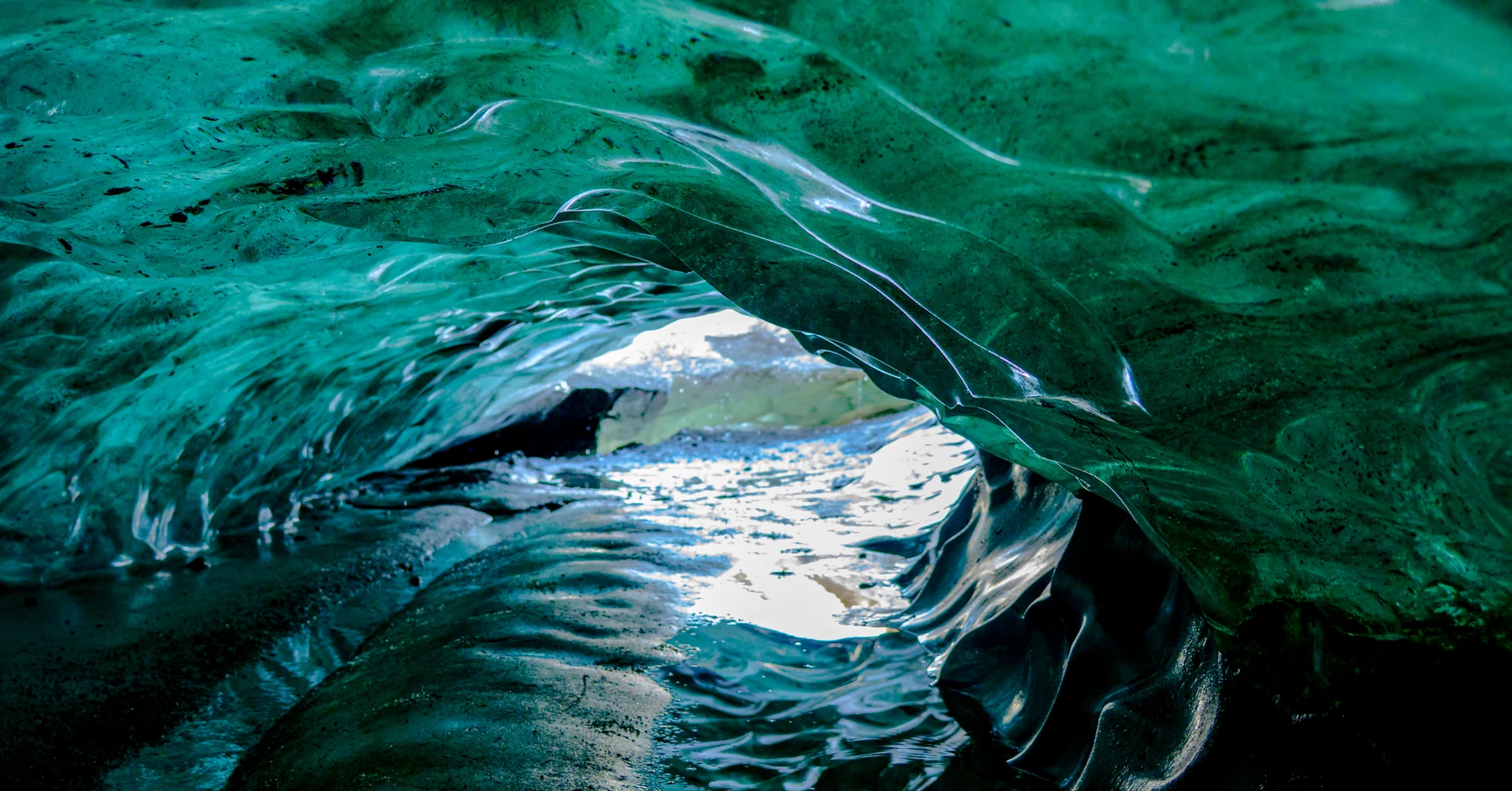 Sculpted blue-green ice framing an opening in an ice cave